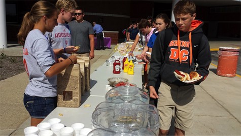 Junior Kayla Gastineau serves chips from Chipolte during Thursday's cookout.