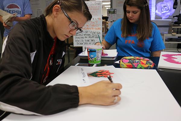 Juniors Madie Shehan (left) and Ashlyn Mills (right) work on projects during 2D art. 