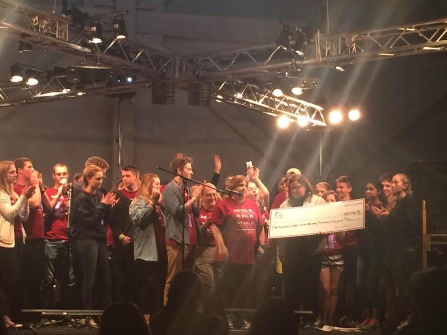 Dance Marathon committee members stand on stage while the total amount of money raised is revealed.