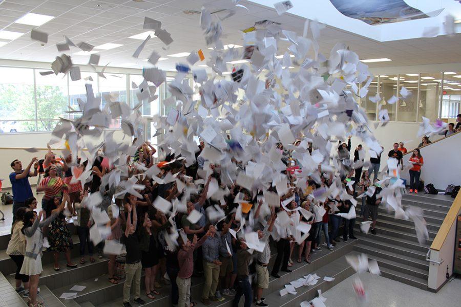 The 2016 senior class throws old papers into the air during the annual paper toss in the Commons.