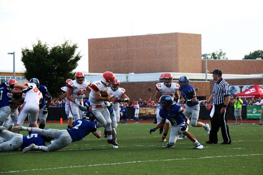 East quarterback Josh Major tries to escape Norths defensive line.