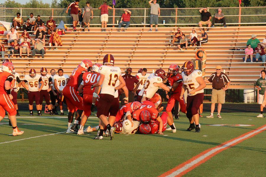 The Os make a team tackle against the Cougars.