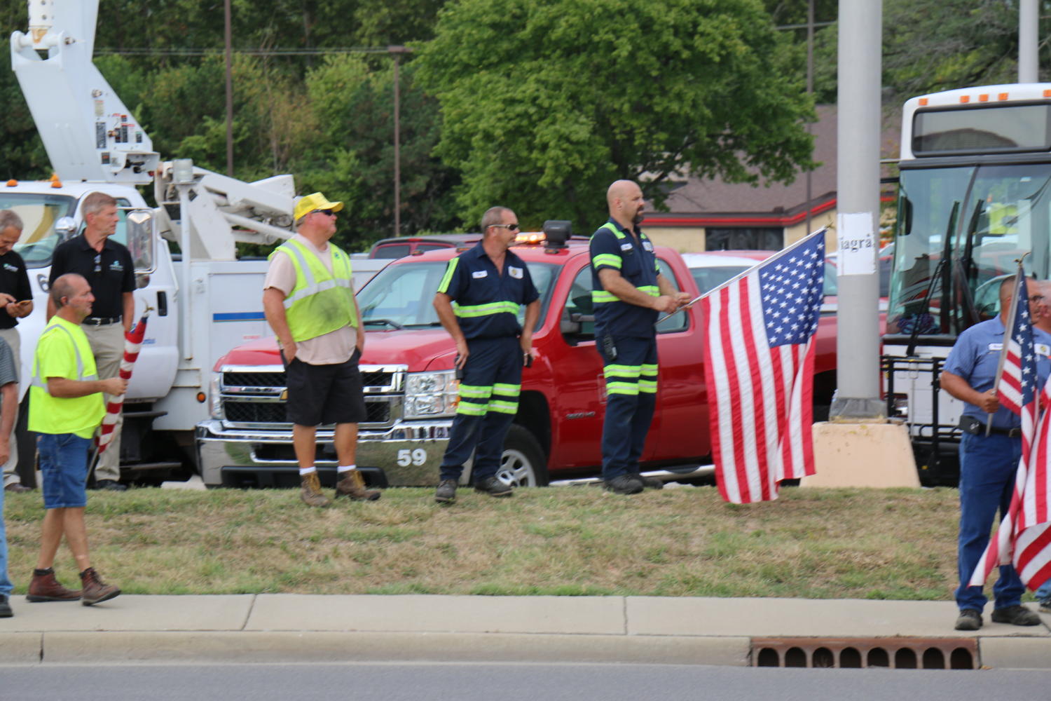 Firefighters wave an American flag as Sgt. Hunters funeral procession passes.