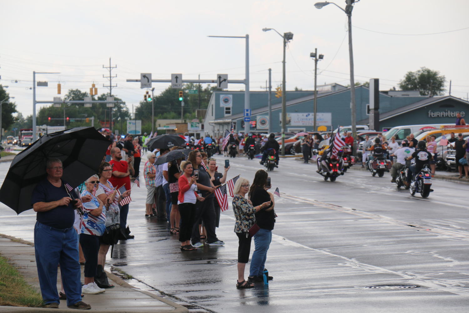 Community members observe Sgt. Jonathan Hunters funeral procession as it travels down 25th Street.