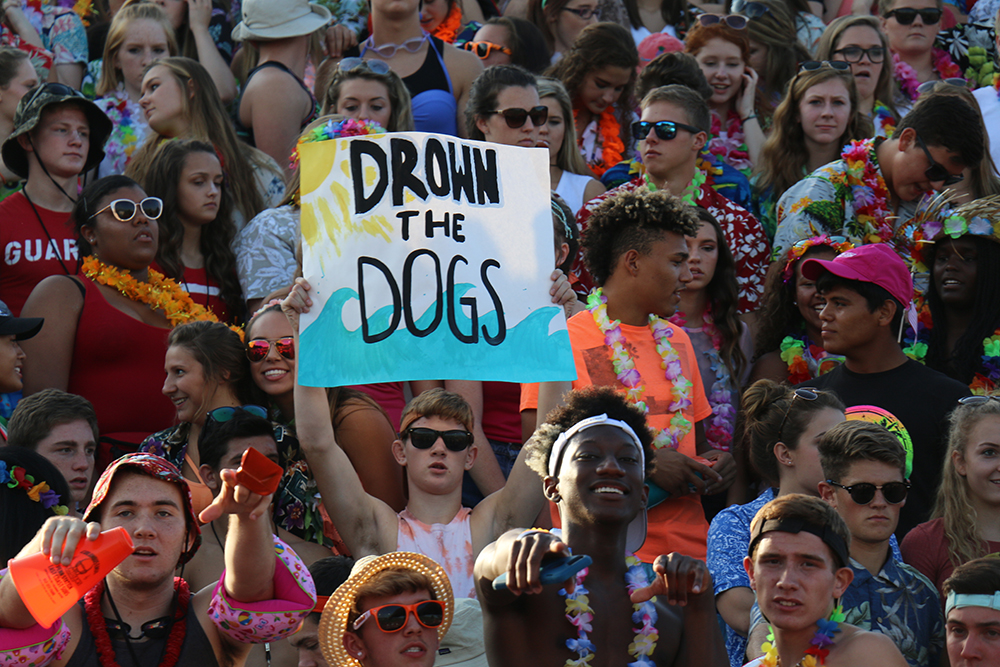 Graham Rooks holds up a drown the dogs sign in the East student section.