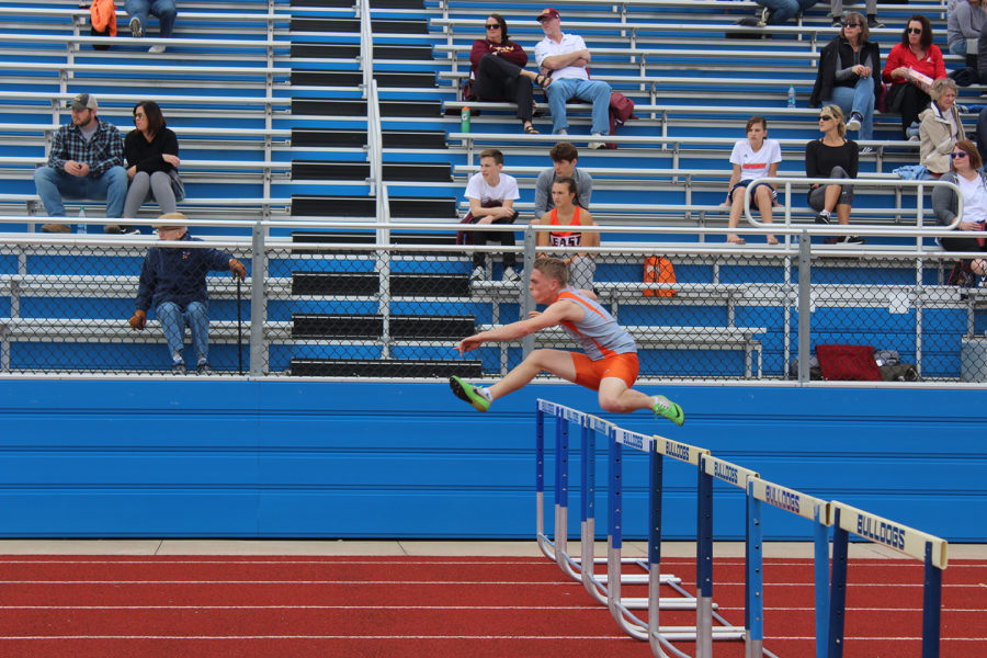 Senior Jared Baker jumps over his third row in the 110 hurdle dash.