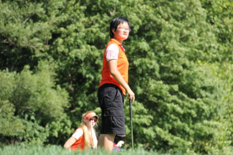 Sophomore Mattie Shoaf, left, and freshman Katie Hong, right, watch their teammate hit the ball.