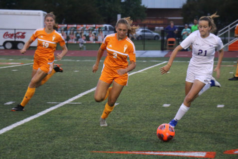 Senior Emily Stiles and freshman Norah Dwenger race to get the ball from Bloomington South.