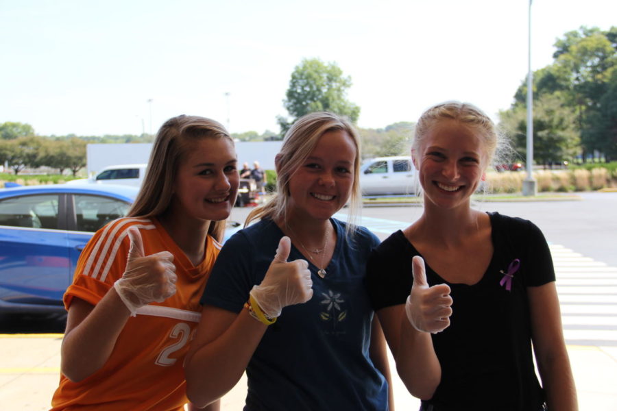 Junior Hannah Hemmerlein, junior Kloe Roberts and junior Marin Wieneke help pass out food at the cookout.