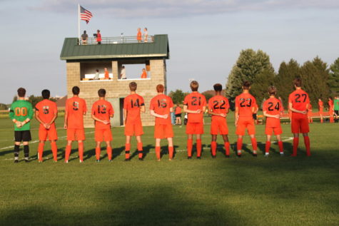 The Olympians face the flag for the playing of the National Anthem.