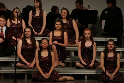 The choir sits down for the beginning of the song