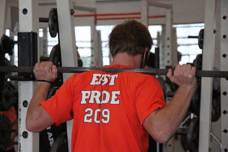 Senior Parker Harrison prepares to squat in weights class. 