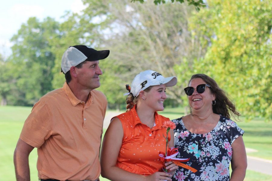 Senior Peyton Meier smiles with her parents. 