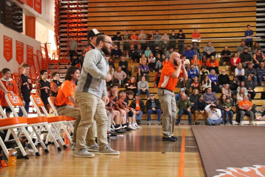 Coaches cheer on wrestlers.